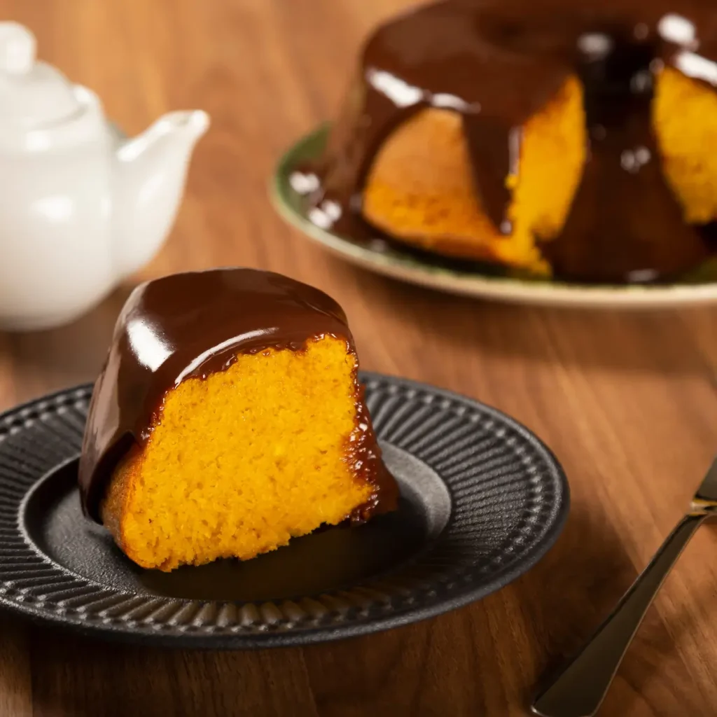Bolo de cenoura com fatia cortada e calda de chocolate