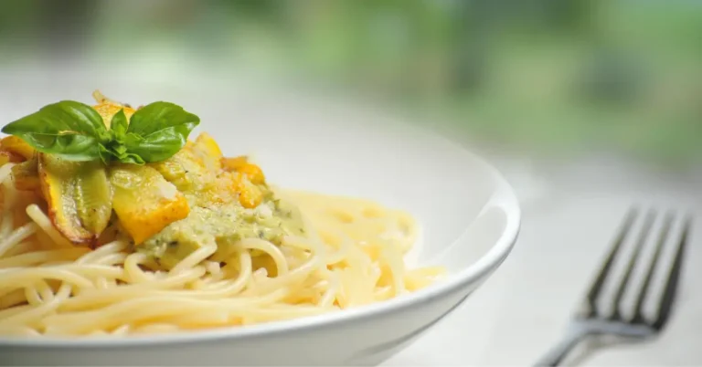 macarrao em um prato branco com garfo ao lado, 7 pratos caseiros.