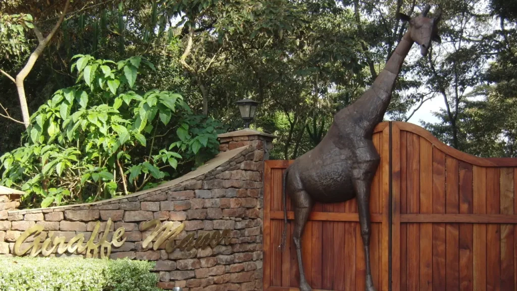 entrada do Giraffe Manor com escultura de girafa em destaque em hotéis temáticos na natureza