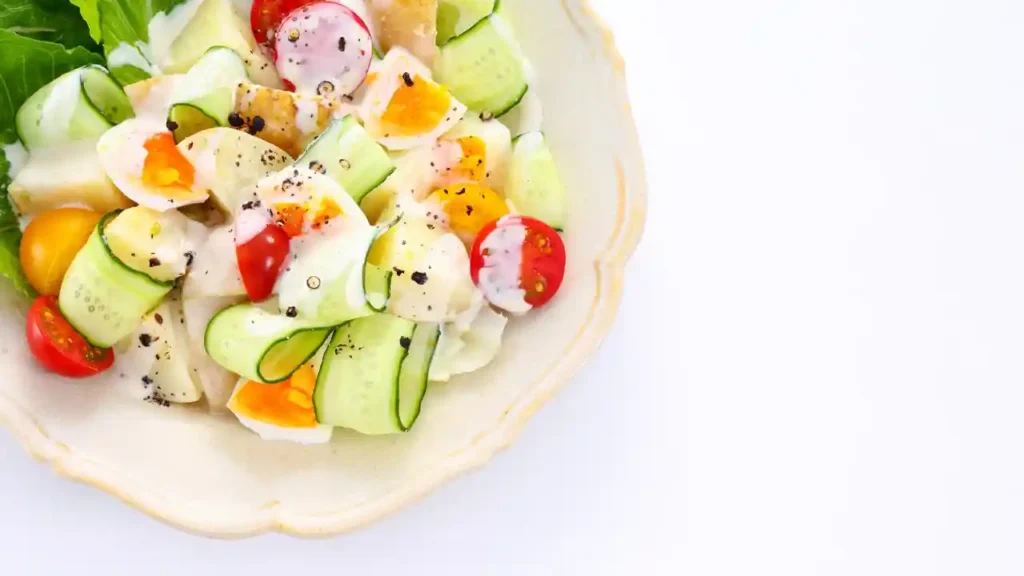Salada fresca com ovos cozidos, tomates-cereja coloridos, pepino e molho cremoso servida como jantar por 10 reais.