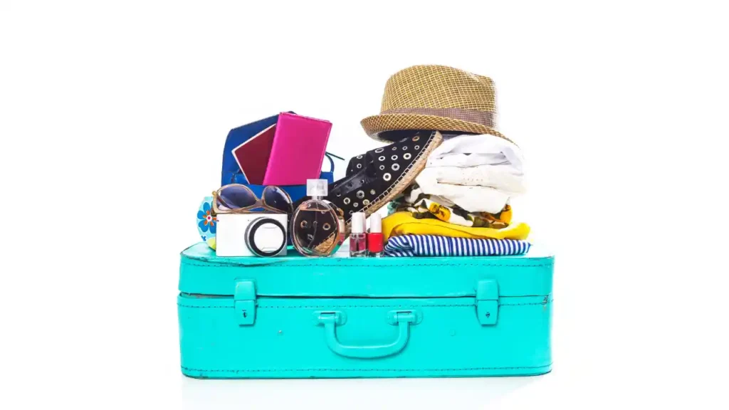 Mala turquesa com roupas, acessórios e itens de viagem organizados — exemplo visual de o que levar na mala para passar 7 dias no litoral.