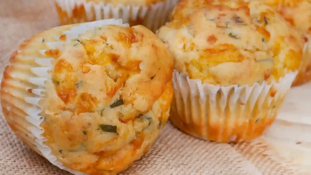 Muffins salgados assados com pedaços de queijo e ervas, sugestão criativa de receita com sobra de arroz.