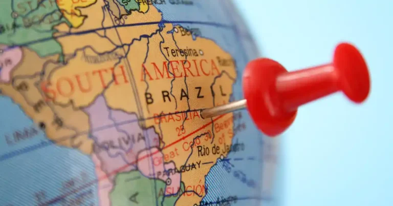 Globo terrestre com alfinete vermelho marcando Brasília, destacando o turismo internacional no Brasil e seu papel como destino estratégico na América do Sul.