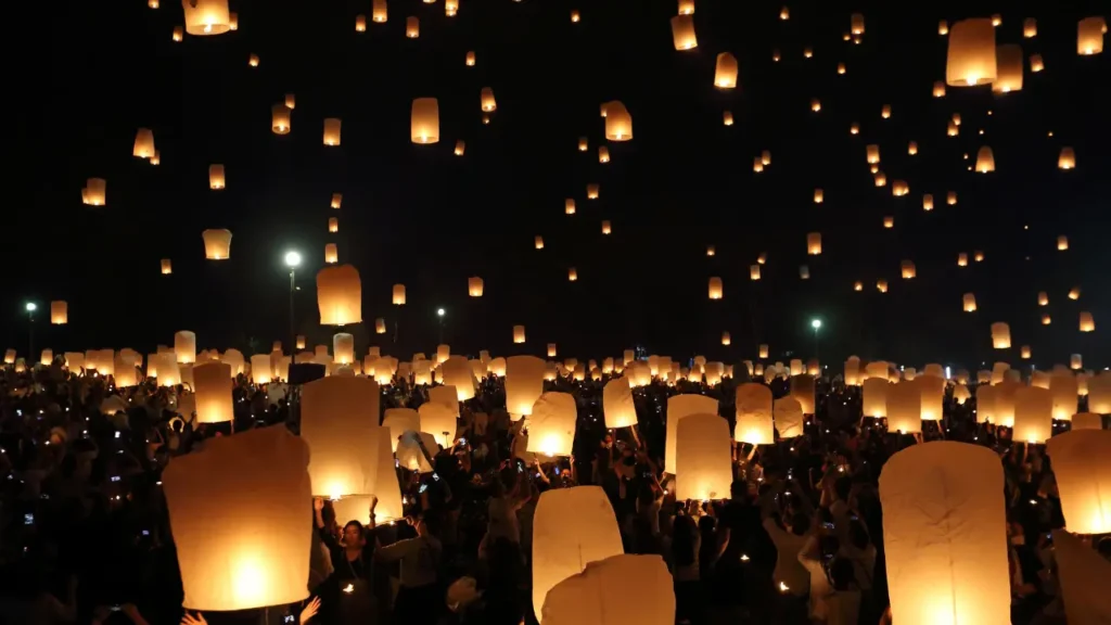 lançamento de lanternas luminosas durante evento noturno em cidade com festival de luz