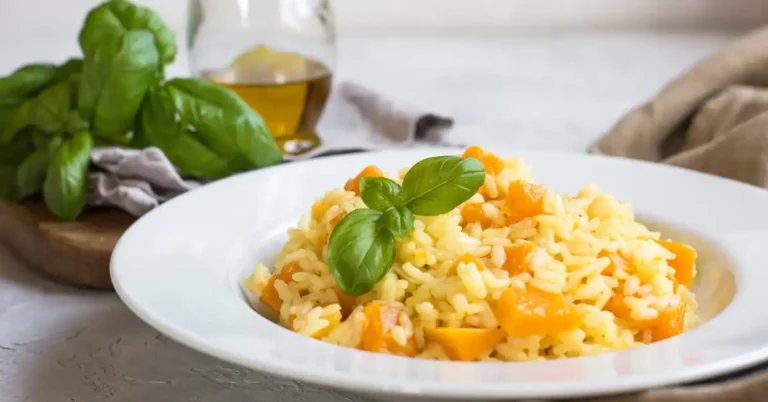 Prato servido de risoto de manga com manjericão fresco, ideal para uma refeição tropical leve e sofisticada.
