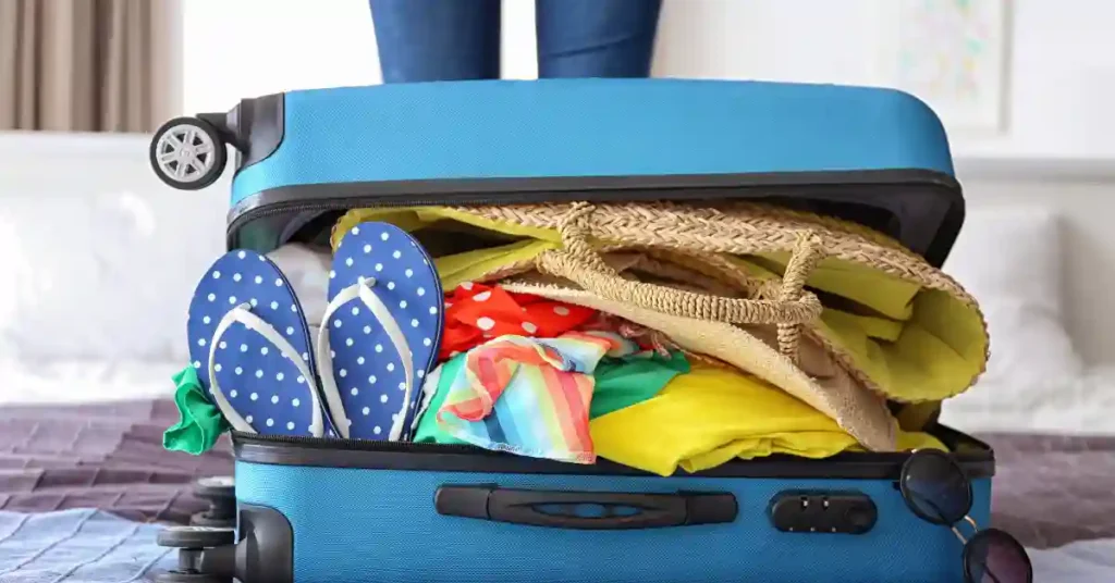 Mala azul abarrotada com itens de viagem em um quarto, simbolizando a preparação para voos diretos rumo à aventura.