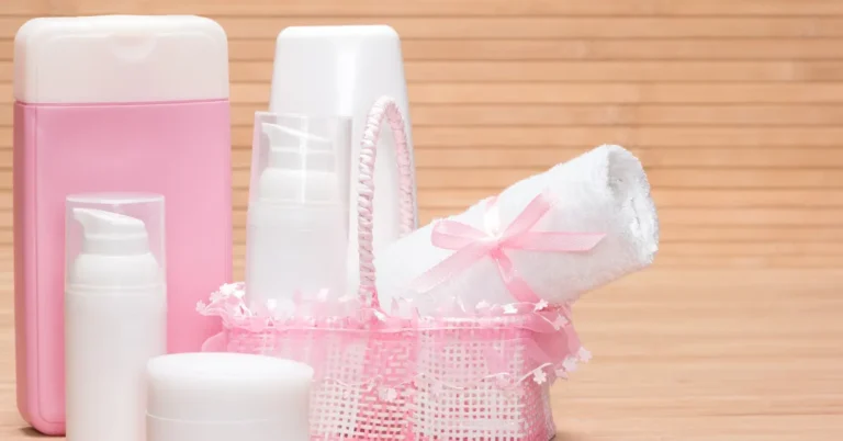 Kit de higiene com toalha, cremes e frascos em tons suaves, simbolizando cuidados essenciais nos primeiros meses do bebê.
