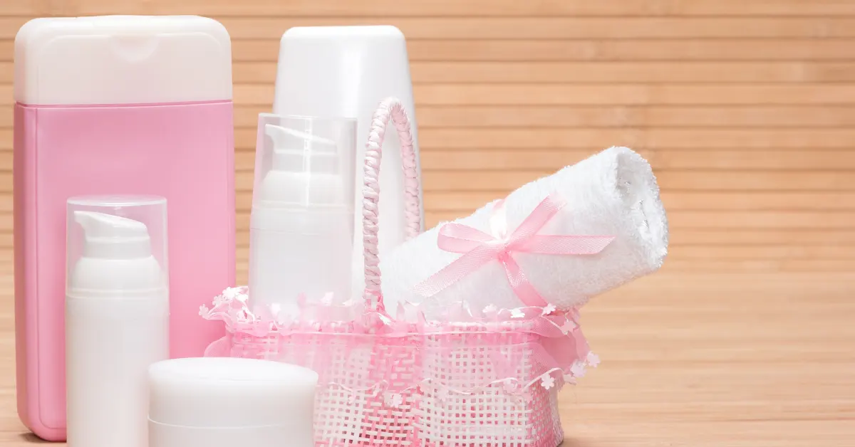 Kit de higiene com toalha, cremes e frascos em tons suaves, simbolizando cuidados essenciais nos primeiros meses do bebê.