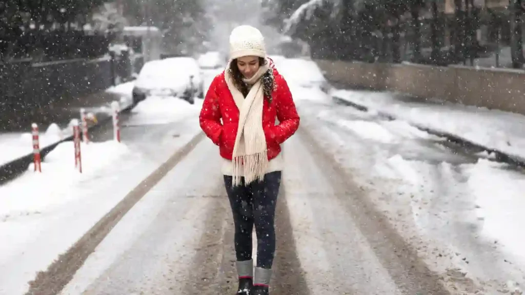 Pessoa caminhando em rua coberta de neve, vestida com roupas de inverno, representando o que levar na mala para o Transiberiano.