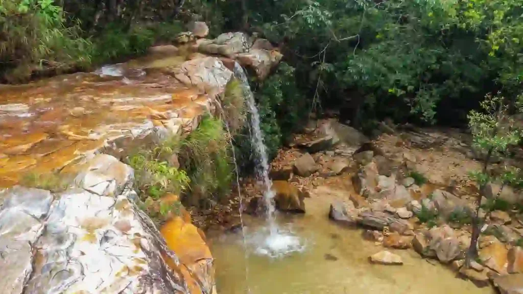 Pequena cachoeira em meio à natureza exuberante, representando um dos destinos energéticos para renovar sua sorte.