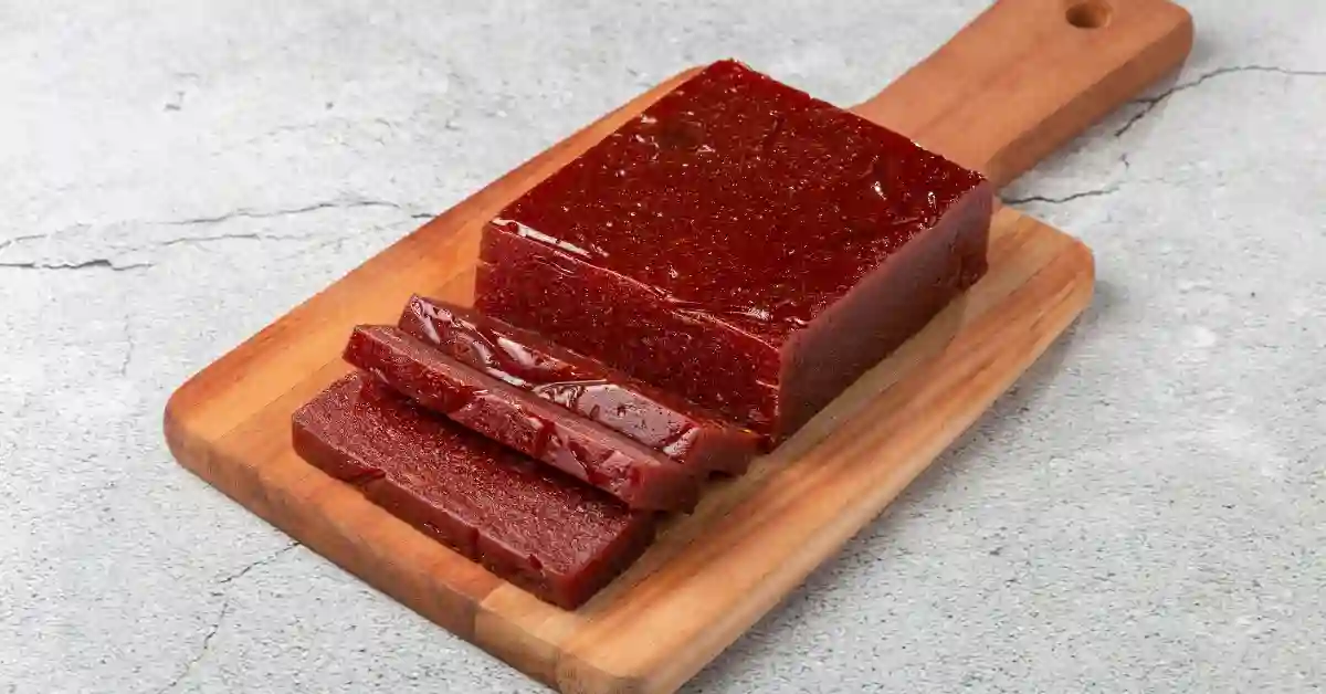 Bloco de goiabada fatiada sobre tábua de madeira — clássico das receitas da Ana Maria Braga.