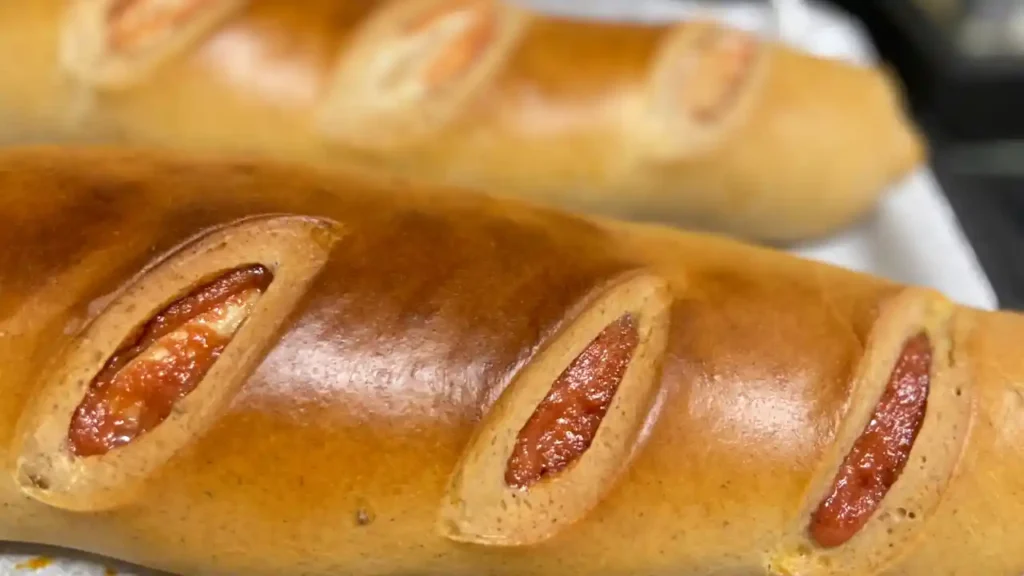 Pães recheados com calabresa ou pepperoni, com casca dourada e brilhante — típicos das receitas da Ana Maria Braga.