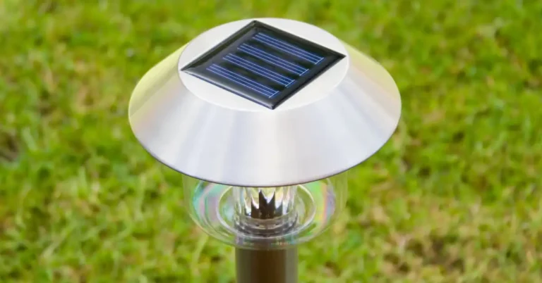 Luminária solar sobre a grama, revelando o segredo da iluminação no quintal com energia sustentável.