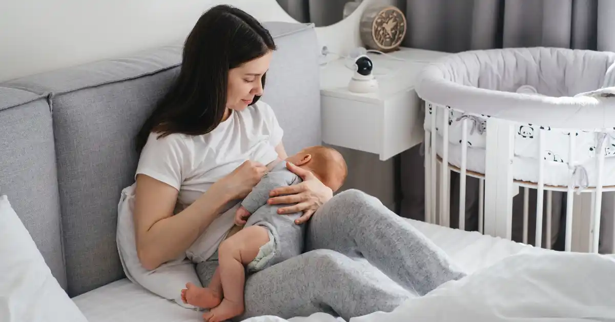 Mãe amamentando seu bebê em um quarto acolhedor — uma cena que revela como a verdade sobre ser mãe muda tudo.
